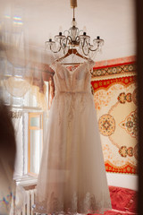 Wedding dress on the chandelier in the room.