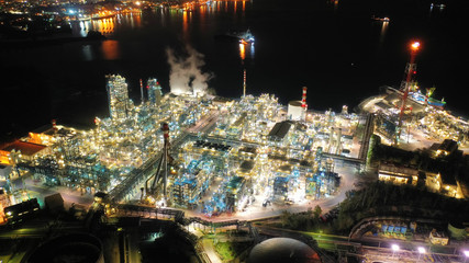 Aerial drone night shot of industrial oil refinery plant with dazzling lights