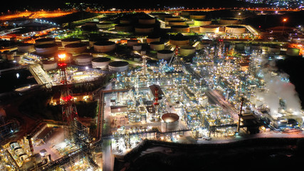 Aerial drone night shot of industrial oil refinery plant with dazzling lights