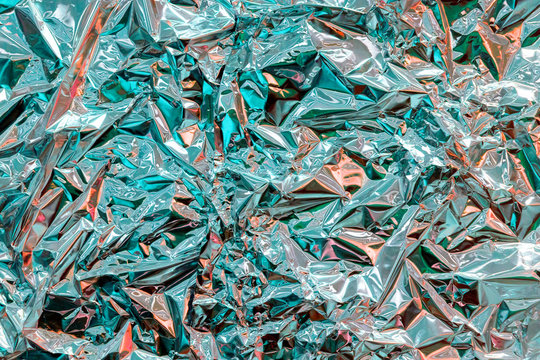 Holographic texture wrinkled metal foil. Hologram abstract 80s style background with blue, purple and silver colors. Texture of kaleidoscope, webpunk and vaporwave concept