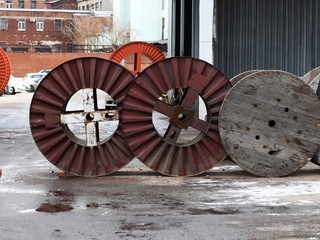 Wooden and metal industrial cable reels in the factory outside