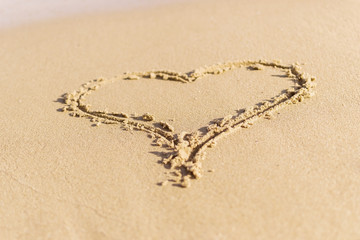Heart the symbol of love drawn in the wet sea sand. The concept of love, honeymoon, Summer holiday.