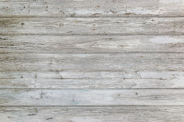 Aged surface of horizontal wooden planks with cracked white paint. Peeling paint on an old wooden wall.
