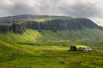 Farm at Balmeanach with cliffs of Creag a Ghaill green slopes and on Loch Na Keal Isle of Mull Scottish Highlands Scotland UK