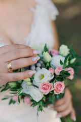 Very beautiful bride is holding a bouquet.