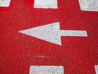 White arrow on the red asphalt surface.