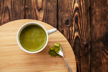 cup of Matcha tea on a round wooden tray