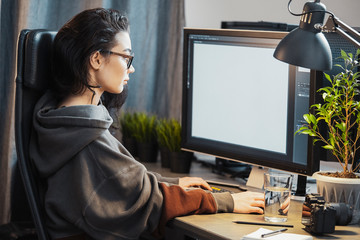Young attractive woman freelancer designer working on pc at home.
