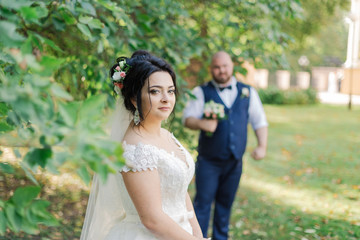 Newlyweds on their wedding day stand apart from each other.