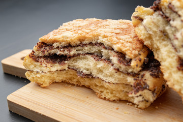 Tasty cookie broken in half. Fresh bread on a kitchen board.