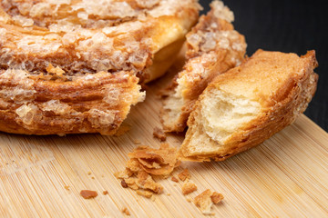 Tasty cookie broken in half. Fresh bread on a kitchen board.