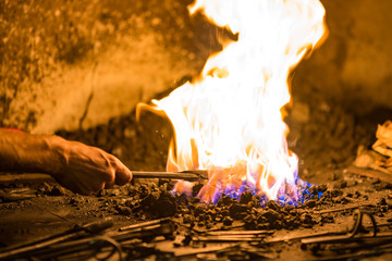 Treatment of molten metal close-up. Handmade blacksmith.
