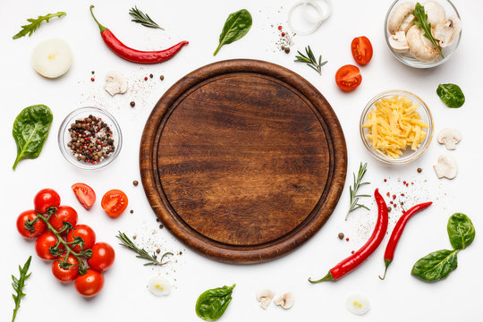 Round cutting board with pizza ingridients around - Powered by Adobe