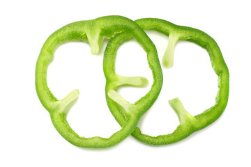 cut slices of green sweet bell pepper isolated on white background top view
