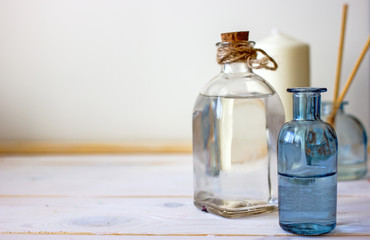 skin care product is placed in the center of the table, in the background there are white towels, incense sticks and white candles. Spa treatments