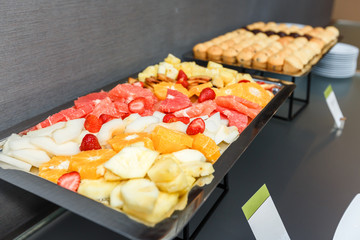 Sliced fruits and Sweet muffins on a served table on a coffee break in the office.