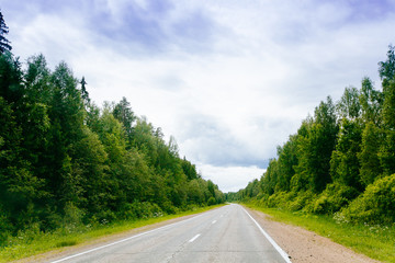 Spring summer background  road in green forest scenery lanscape with blue sky
