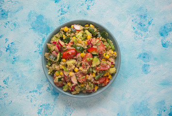 Green salad with radish, quinoa and corn on plate.