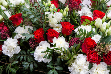 background of red roses, white carnations and green leaves