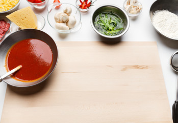 Pizza cooking ingredients and sauce in bowls