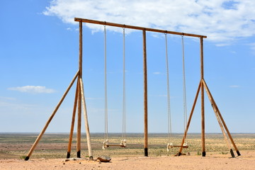 Lonely swings in the middle of the desert.