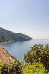 Italy, Cinque Terre, Corniglia, a body of water with a mountain in the background