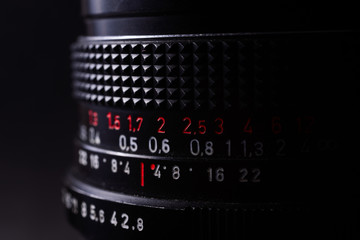 Vintage lens scale signs closeup. Stock photo with blurred gray background.