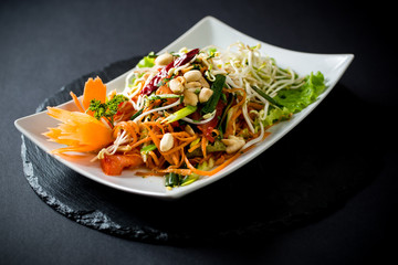 Papaya salad (Som Tam) , Thai food. Four essential flavors of Thailand. Sour, sweet, spicy and exotic. Served with homemade chili sauce.