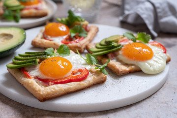 Baked puff pastry with fried egg, pepper and avocado