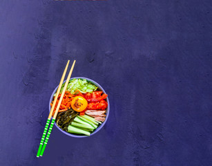 Traditional dish of Korean cuisine. Bibimbap with beef, vegetables and egg on blue background. 