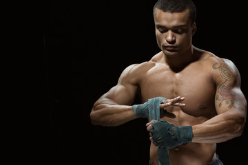 Obraz na płótnie Canvas Confidence and tranquility. Studio shot of an African male boxer doing bandages