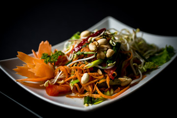 Papaya salad (Som Tam) , Thai food. Four essential flavors of Thailand. Sour, sweet, spicy and exotic. Served with homemade chili sauce.
