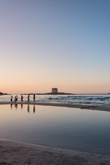 Ragazzi camminano sulla spiaggia al tramonto al mare.