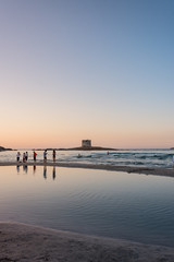 Fototapeta premium Ragazzi camminano sulla spiaggia al tramonto al mare.