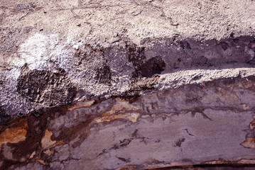 Cracked gray paint, plaster surface on wall, grunge horizontal shabby background detail close up
