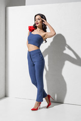 Brunette model in colorful clothing and accessories posing in studio