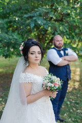 Newlyweds on their wedding day stand apart from each other.