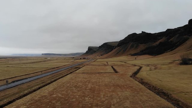 Icelandic cliffs on the southern coast with the ringroad and passing cars near foss a sidu 
