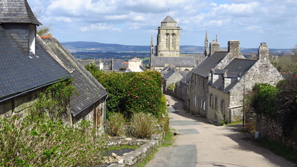 Village de Locronan, ruelle et vue sur le clocher de l'église Saint-Ronan (France)