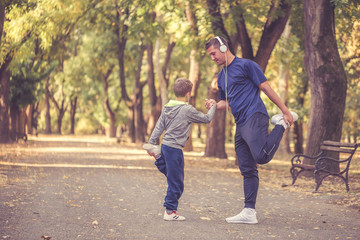 Obraz premium Little boy and his father exercising together outdoors