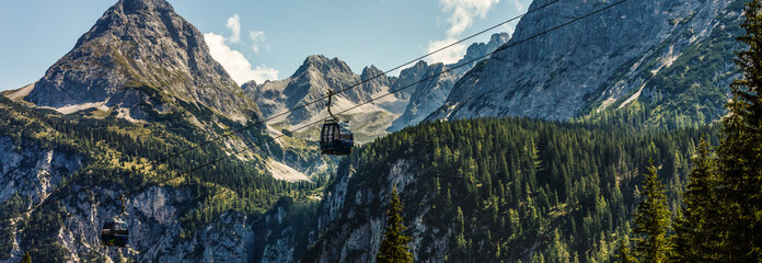 Two cabs of the cableway and skiers on the slope of the mountain Chopok south side on a sunny day in the ski © Angelov