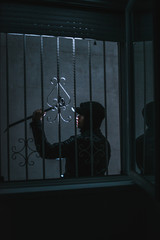 Burglar breaking into a house via a window with a crowbar