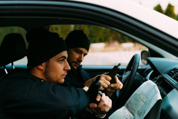 Thieves parked in an ally waiting and planning the way they will rob their target.