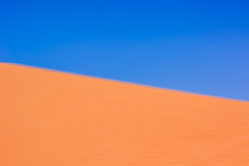 abstract fuzzy blue and yellow colorful unfocused background pattern from idyllic desert dunes landscape, copy space