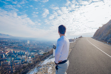 A young strong fit masculine man working out in the morning while looking at the city.