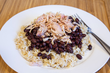 A dinner plate with Chicken Beans and Rice and a fork