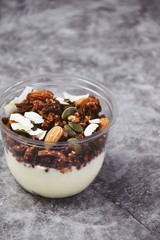 Chocolate and coffee yogurt granola in a plastic jar. Granola dessert for take away. Healthy street food granola  