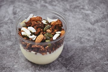 Chocolate and coffee yogurt granola in a plastic jar. Granola dessert for take away. Healthy street food granola  