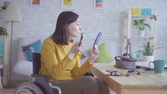 Portrait of a young disabled woman in a wheelchair doing makeup going on a date