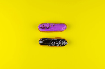 Two beautiful and delicious eclairs on a bright yellow background.